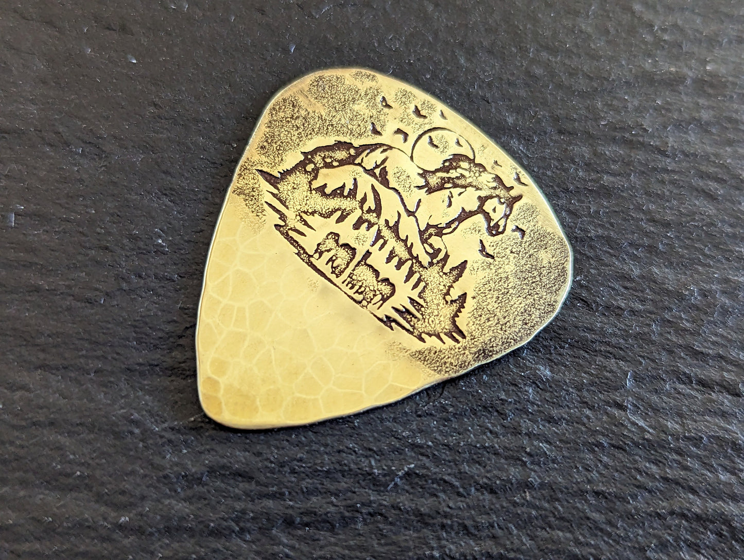Brass guitar pick with forest and horses - playable brass plectrum