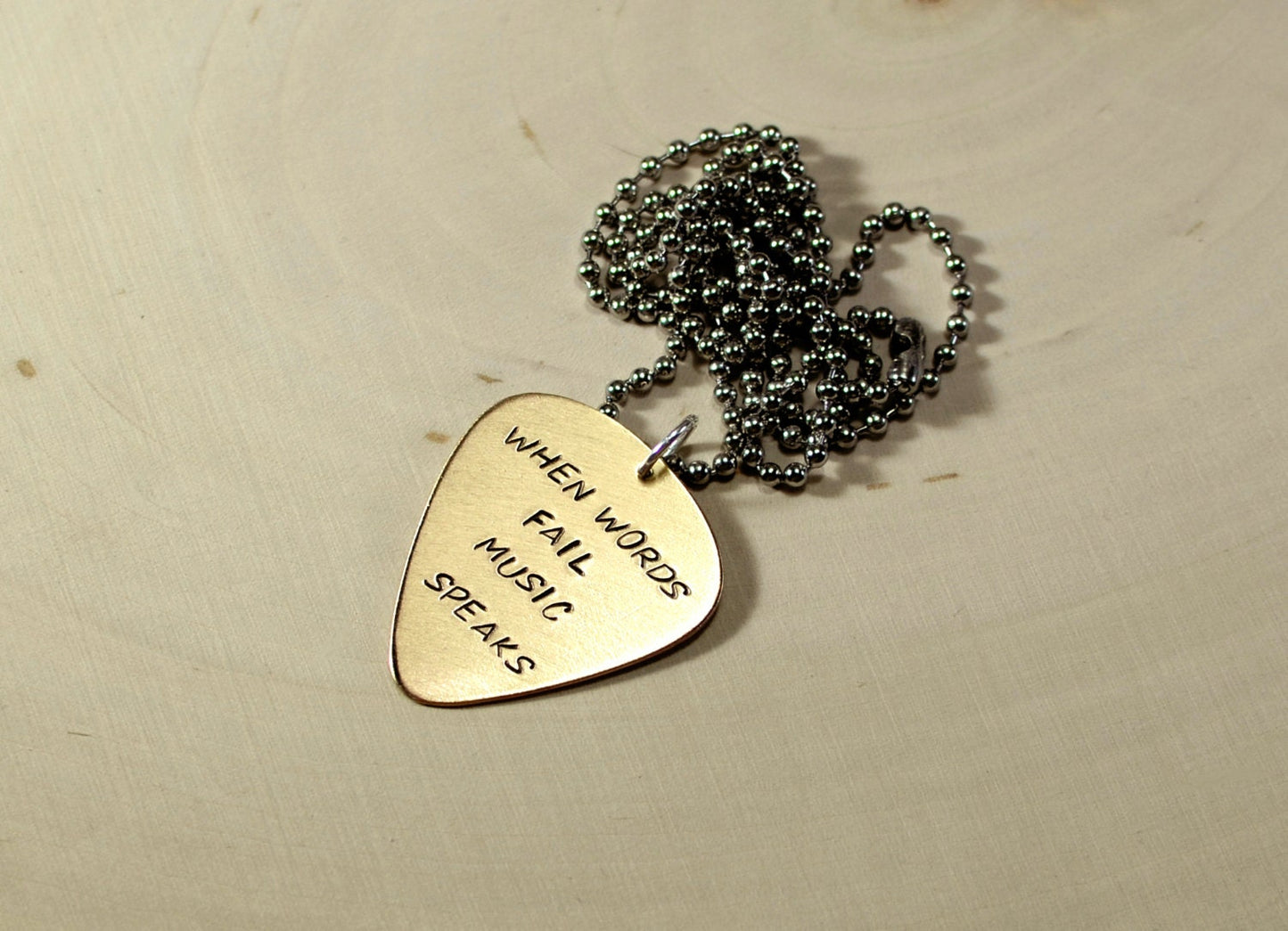 When words fail music speaks on a 14K solid yellow gold guitar pick necklace