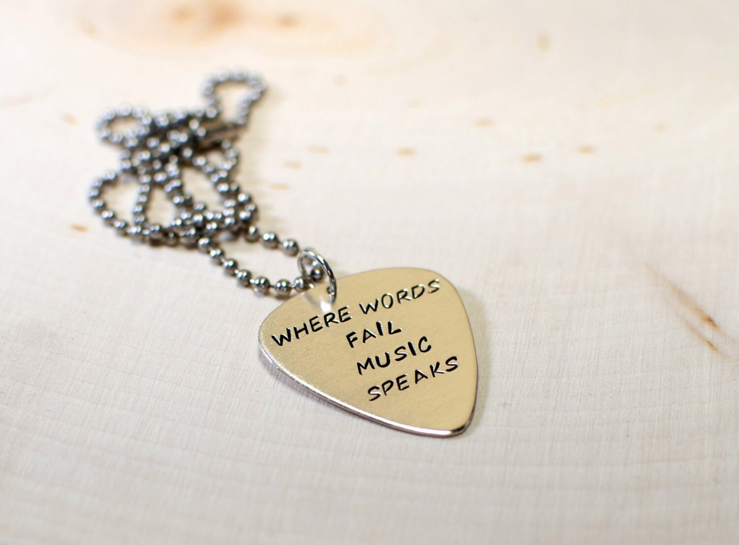 Necklace with Where words fail music speaks on sterling silver guitar pick