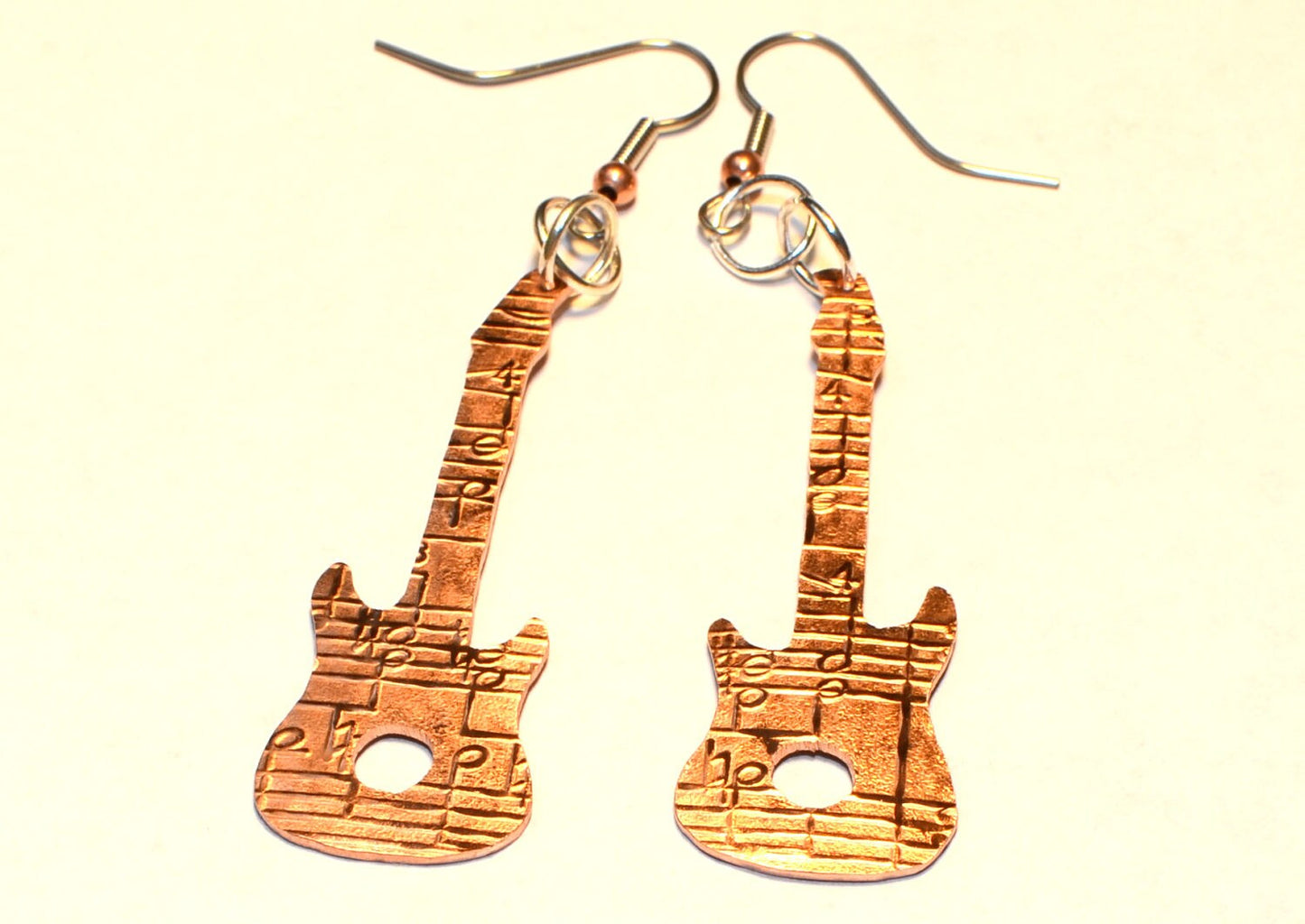 Copper guitar shaped earrings with music notes