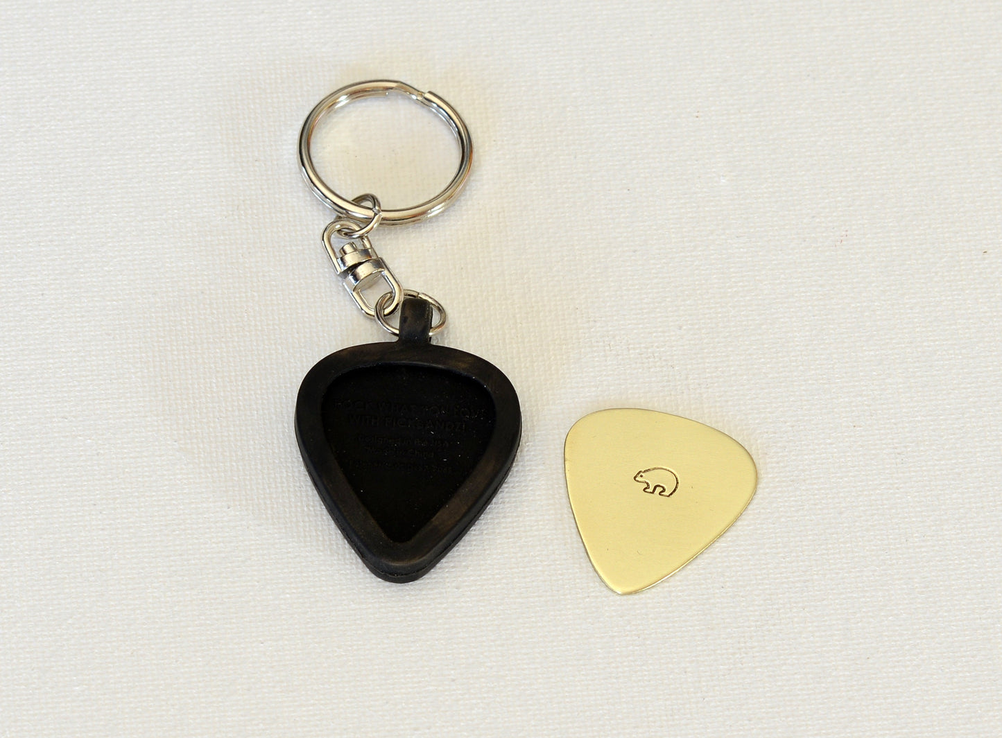 Brass guitar pick and a rubber guitar pick holder keychain