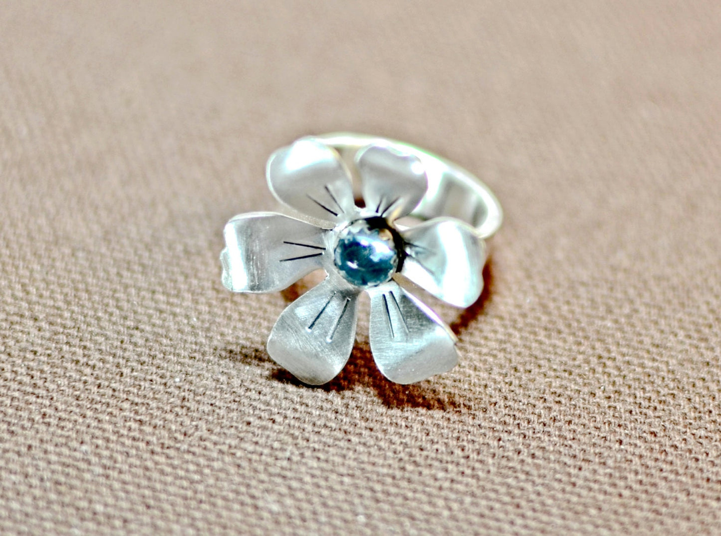 Flower shaped sterling silver ring with blue topaz