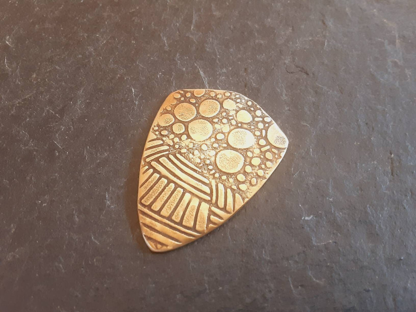 Brass shield guitar pick - playable with wild pattern - backside hammered - NicisPicks Original