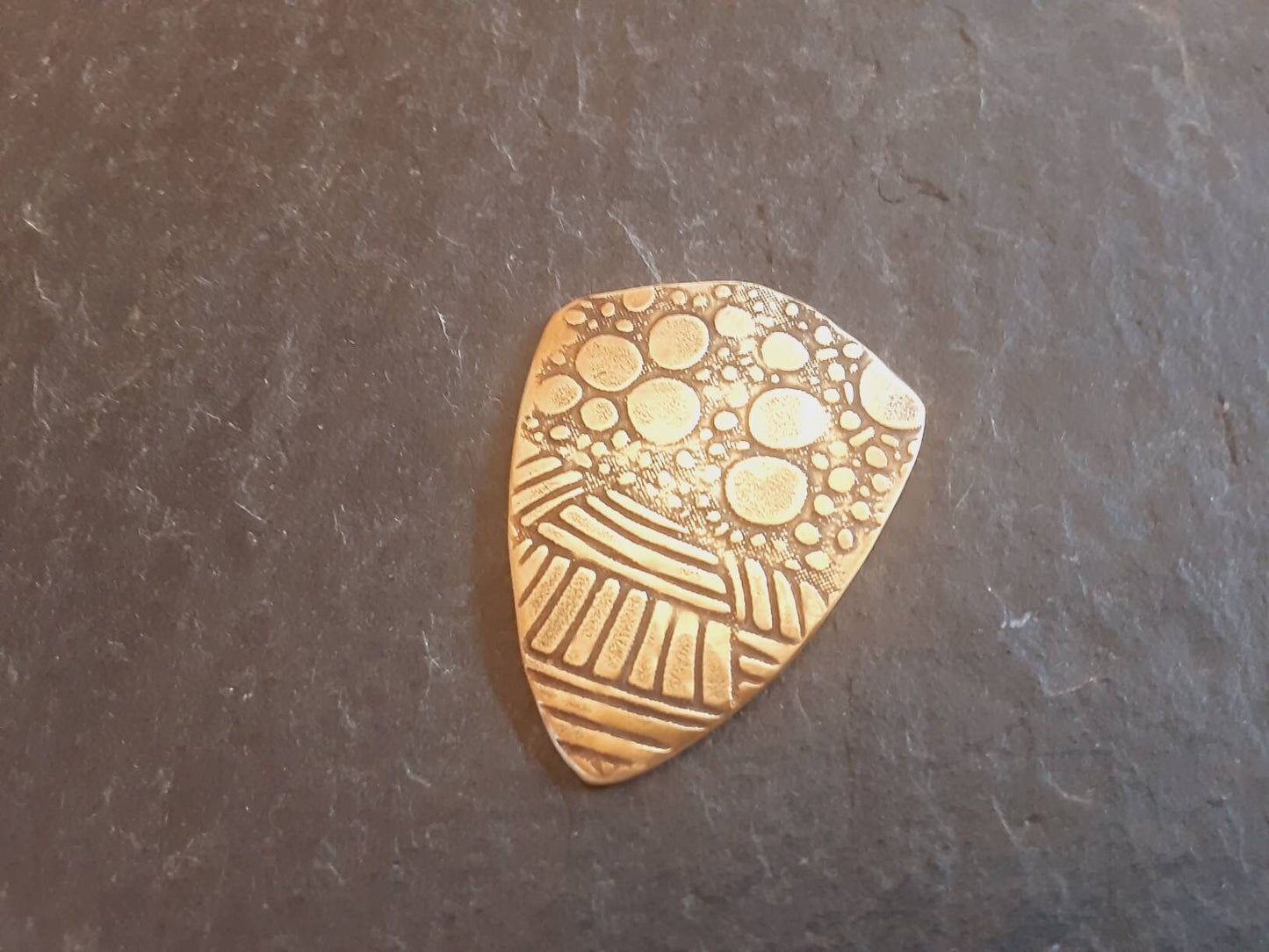 Brass shield guitar pick - playable with wild pattern - backside hammered - NicisPicks Original