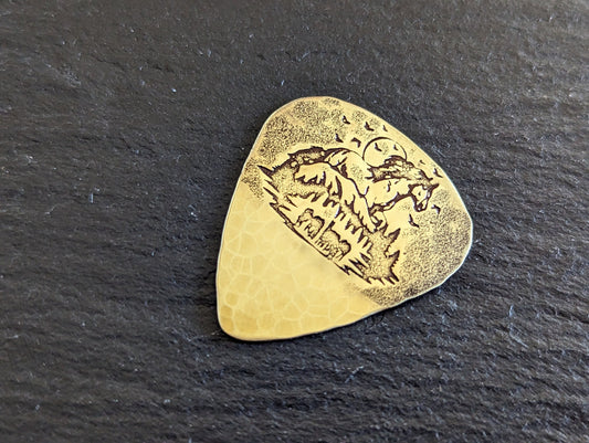 Brass guitar pick with forest and horses - playable brass plectrum