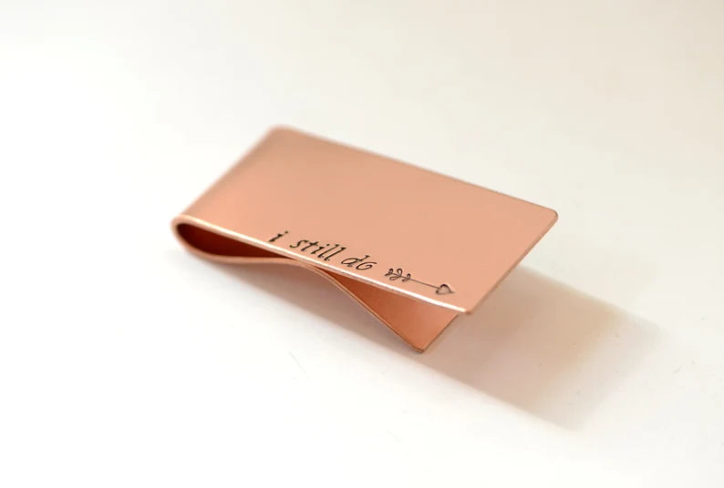 Copper money clip with I still do and an arrow