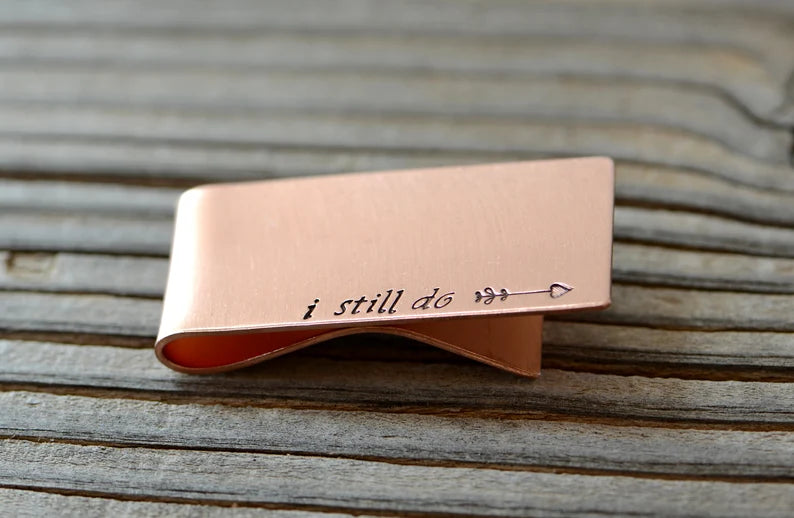 Copper money clip with I still do and an arrow