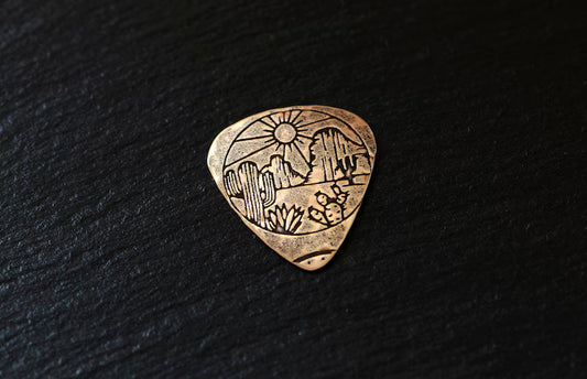 Bronze guitar pick with desert landscape - handmade and playable