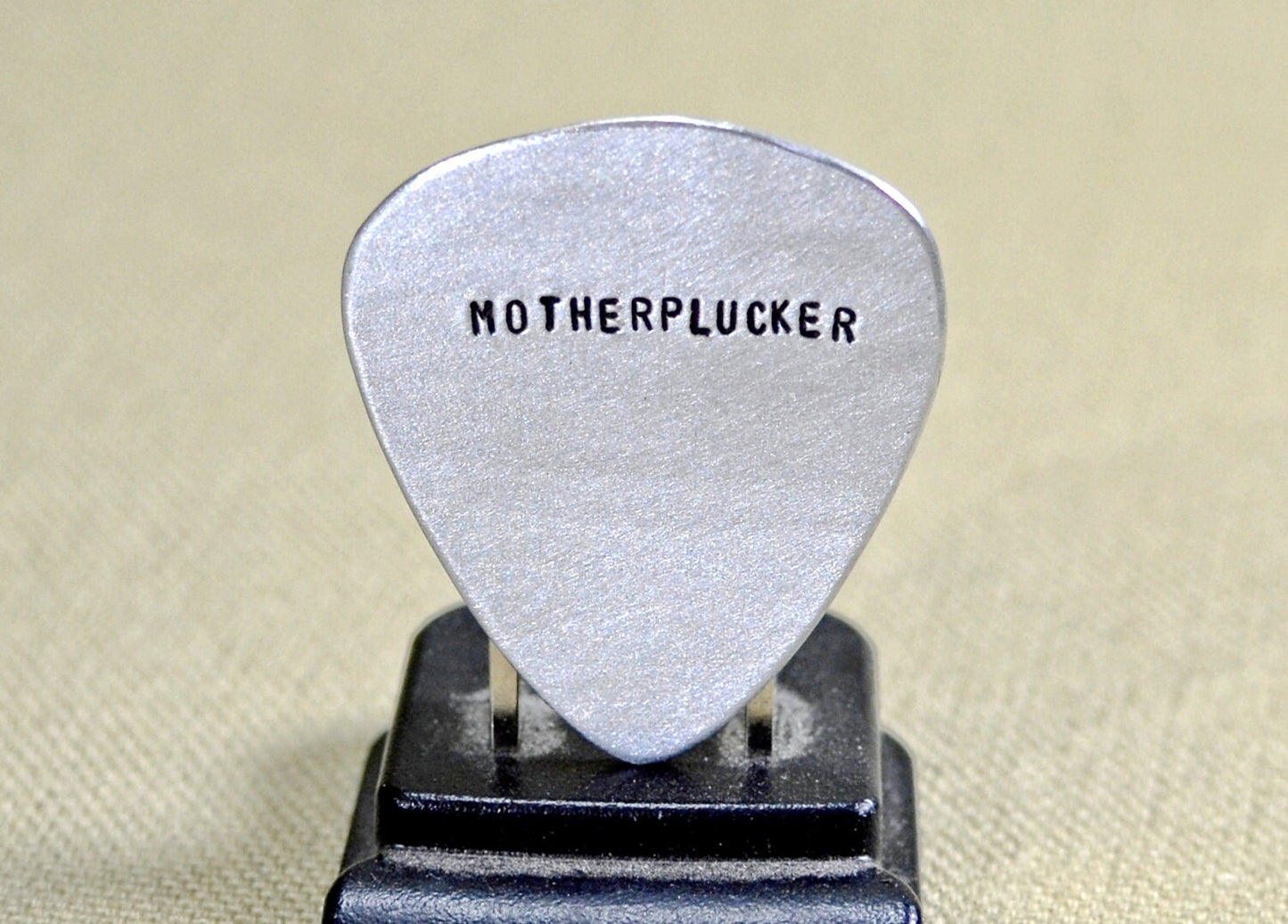 Sterling silver guitar pick with hand stamped Motherplucker