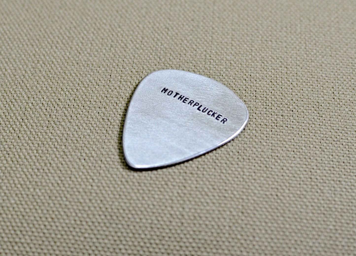 Sterling silver guitar pick with hand stamped Motherplucker