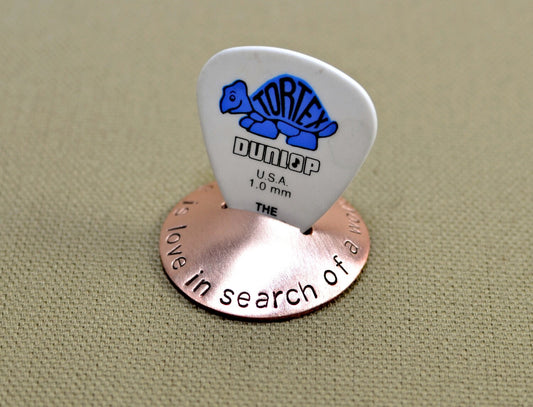 Copper guitar pick stand with "music is love in search of a word