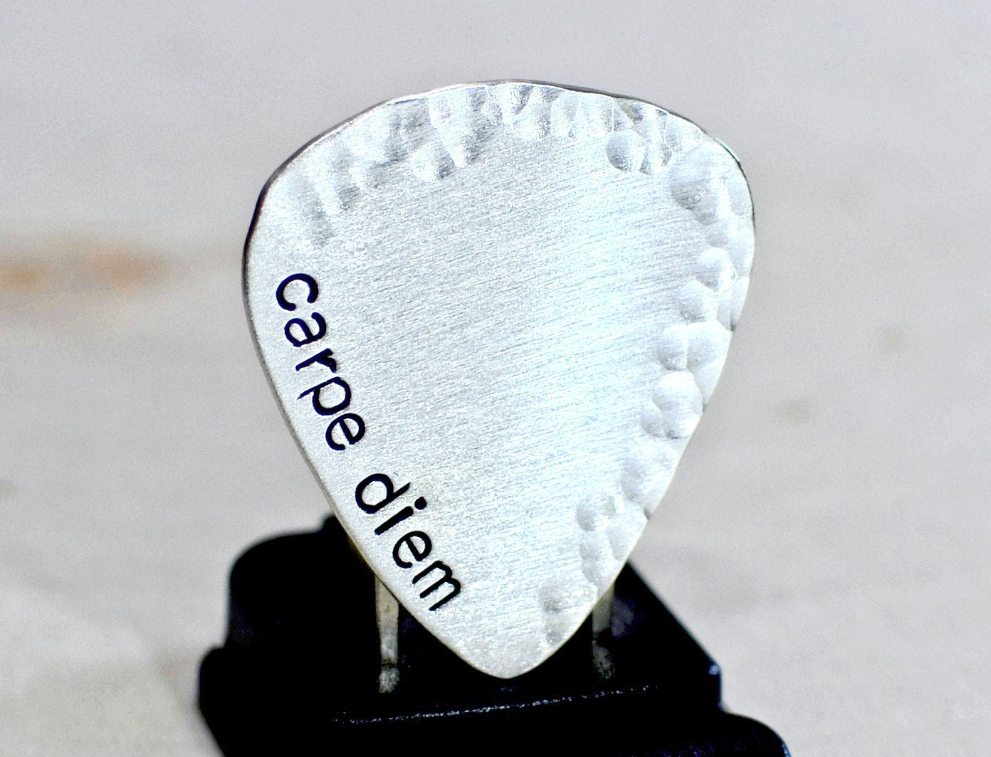 playable sterling silver guitar pick with carpe diem and a hammered border