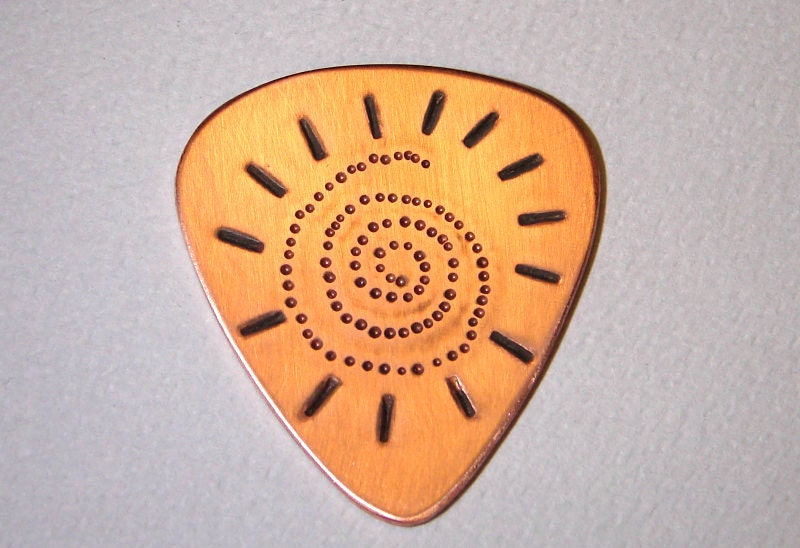 Spiral sun chased and dotted on copper guitar pick
