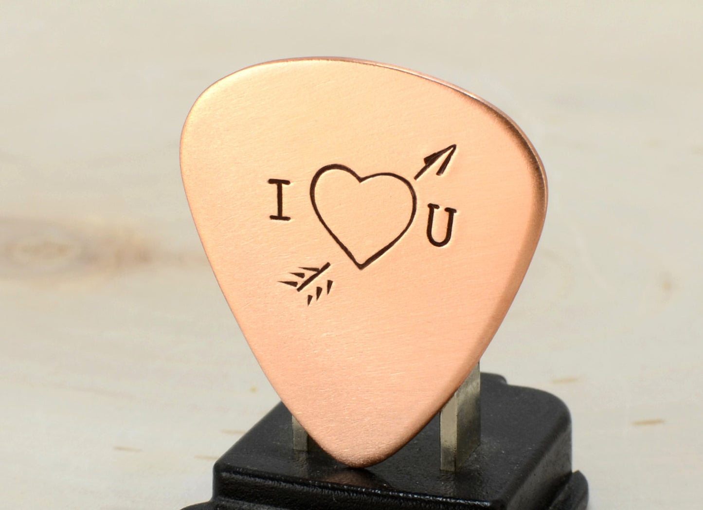 I love you copper guitar pick with Cupid's arrow of love straight through the heart