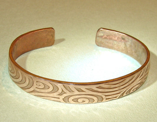 Swirling design on a cuff bracelet in heavy copper