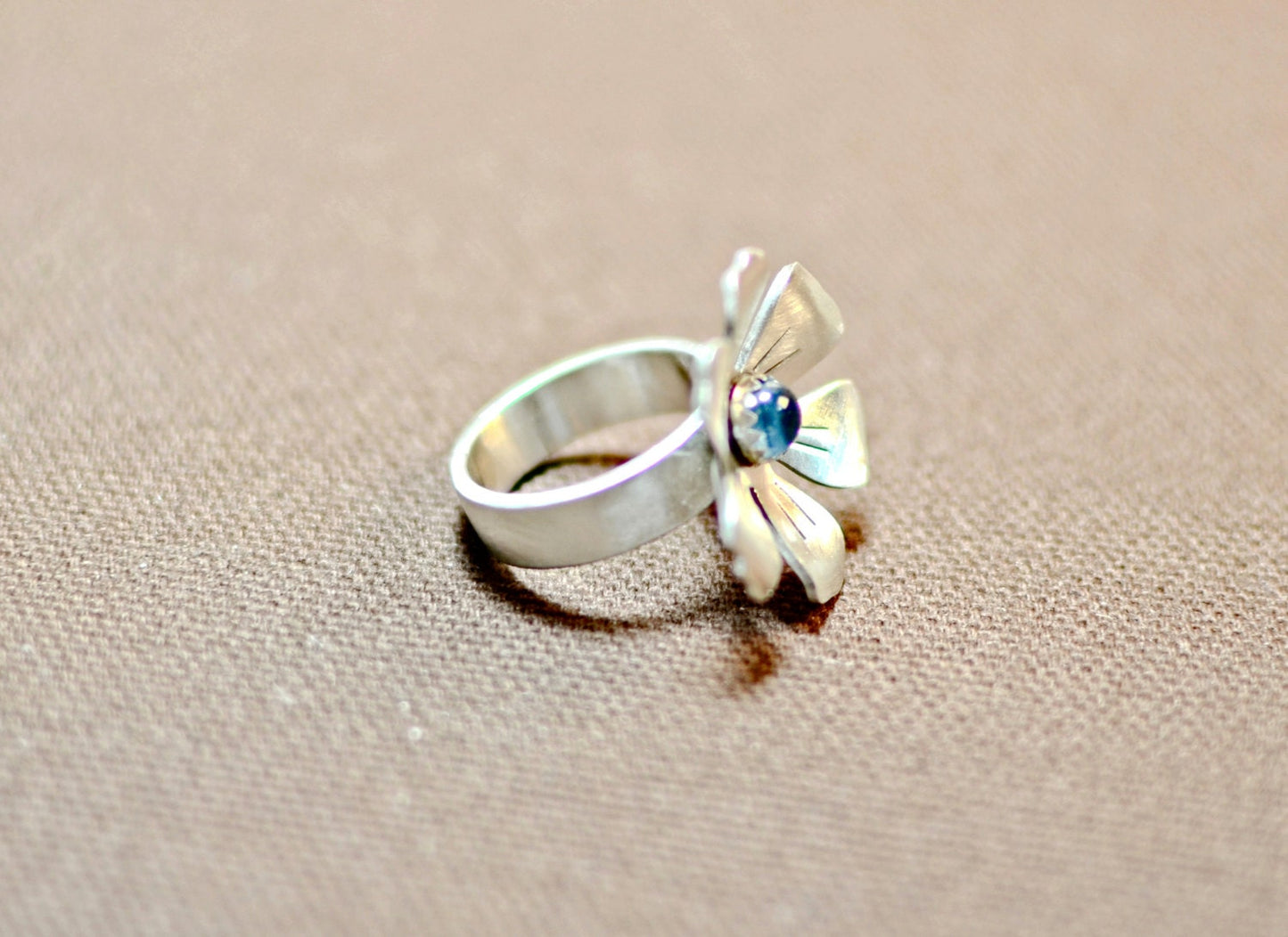 Flower shaped sterling silver ring with blue topaz