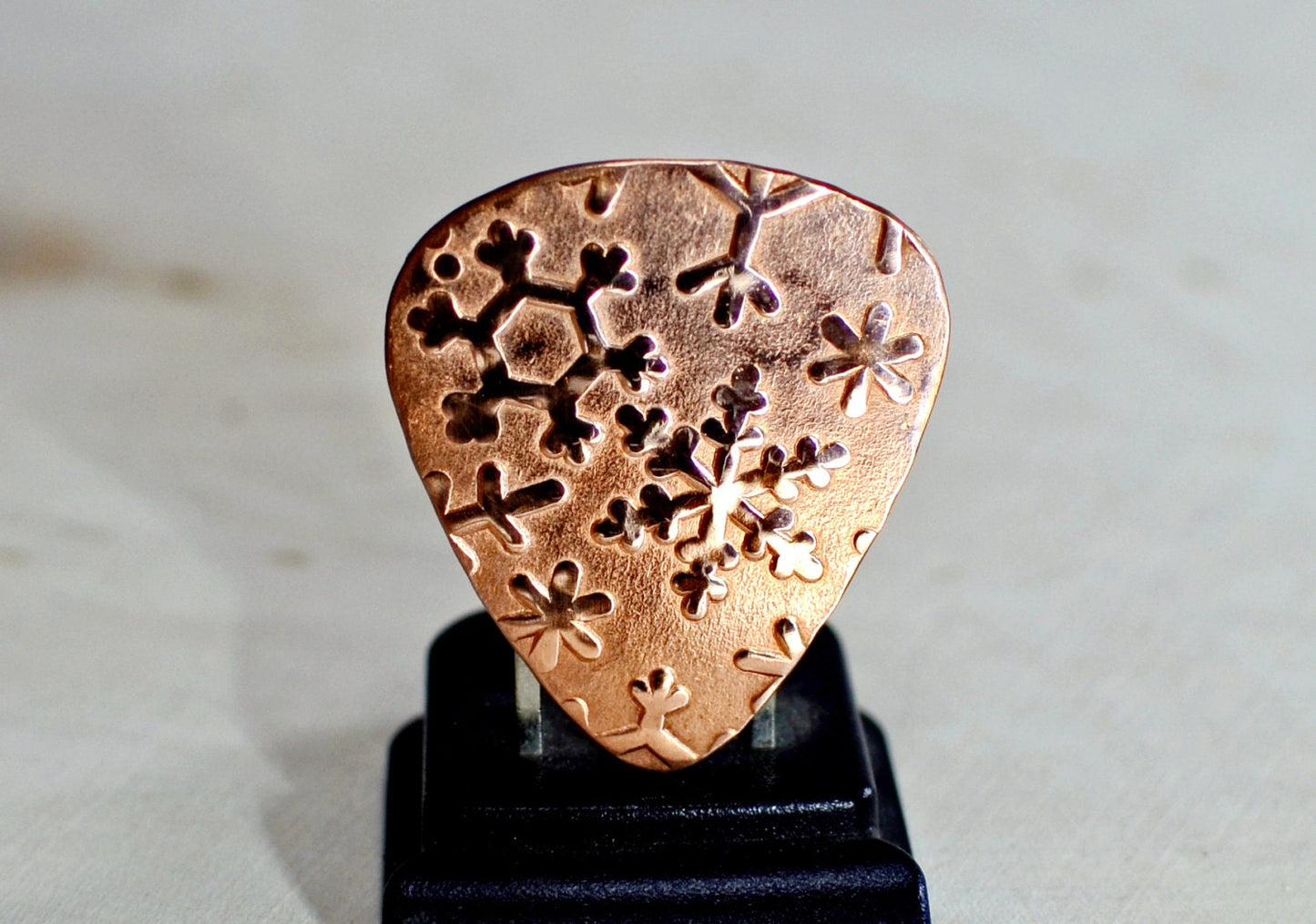 Snowflakes on copper guitar pick and a stand as shown in photo number 7