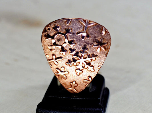 Snowflakes on copper guitar pick and a stand as shown in photo number 7