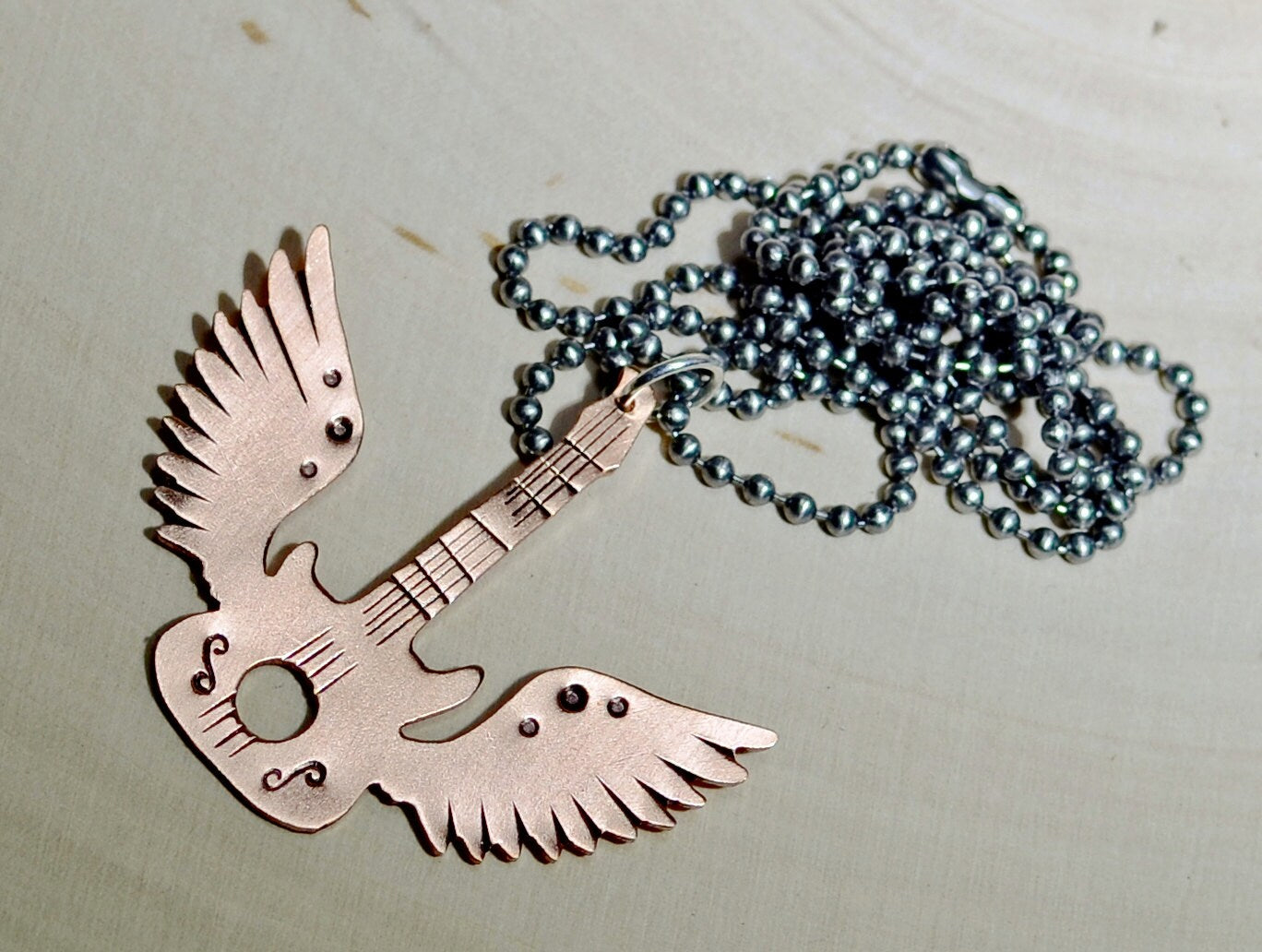 Copper winged guitar necklace