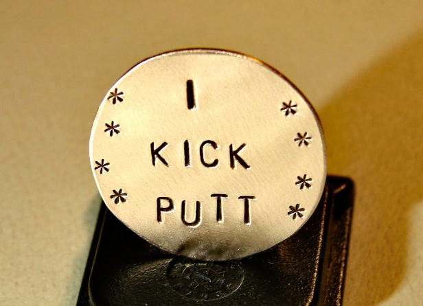 Bronze golf ball marker with I kick putt