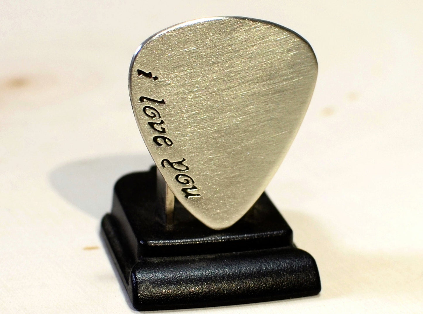 sterling silver guitar pick with I love you in cursive