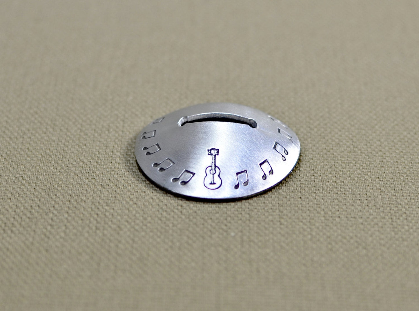 Aluminum disc shaped guitar pick stand with musical inspiration