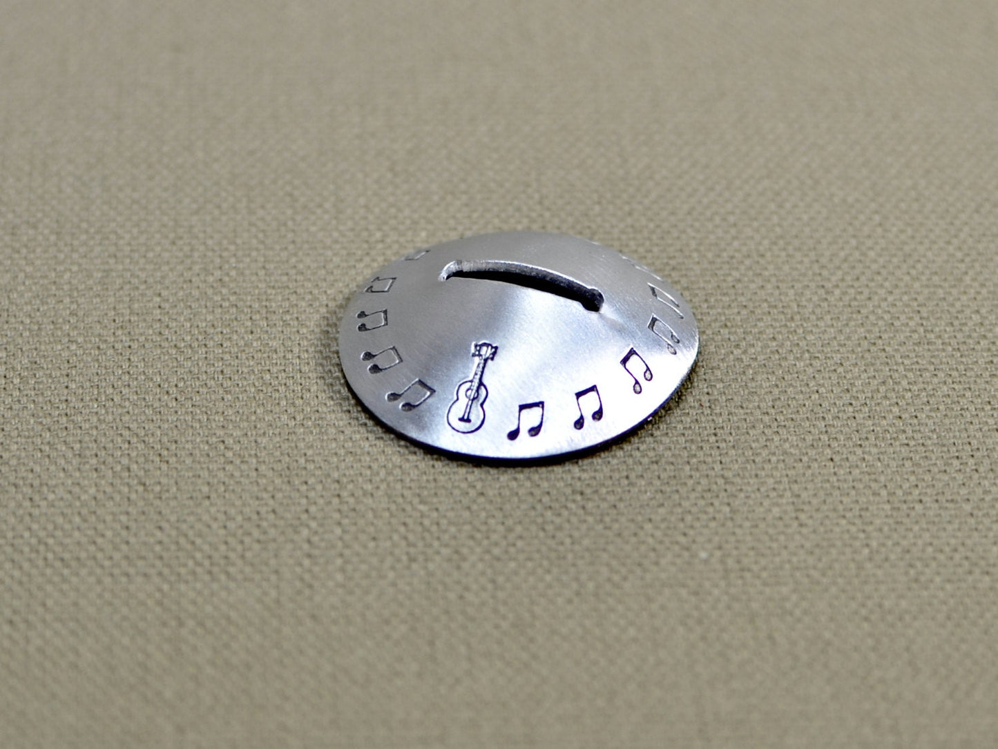 Aluminum disc shaped guitar pick stand with musical inspiration
