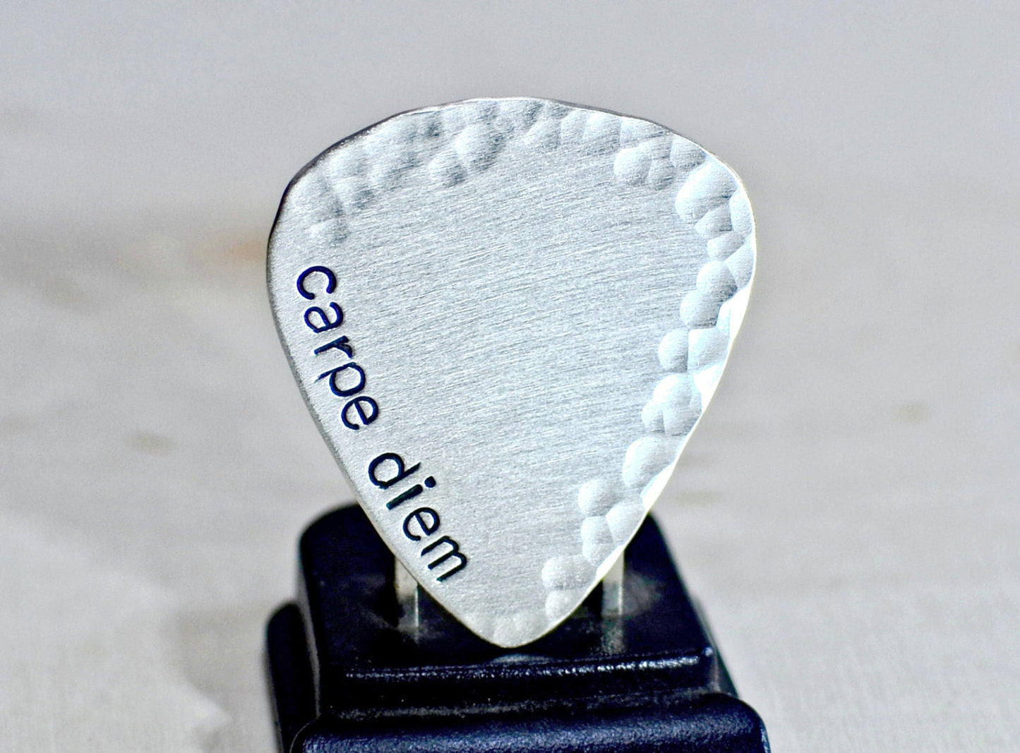 playable sterling silver guitar pick with carpe diem and a hammered border