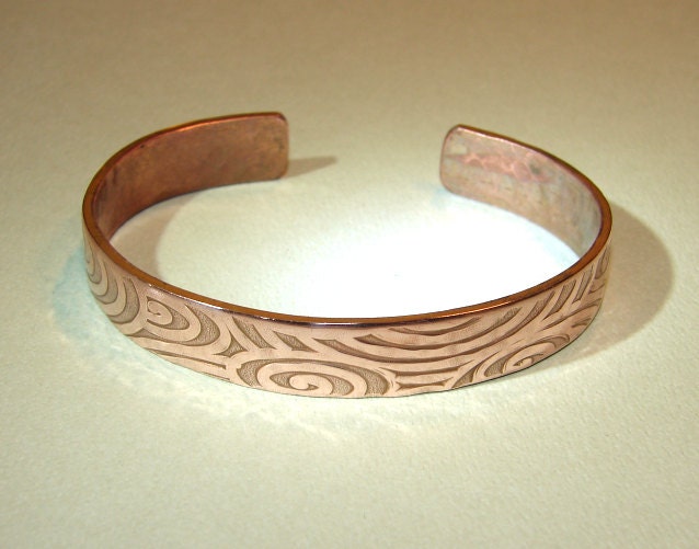 Swirling design on a cuff bracelet in heavy copper