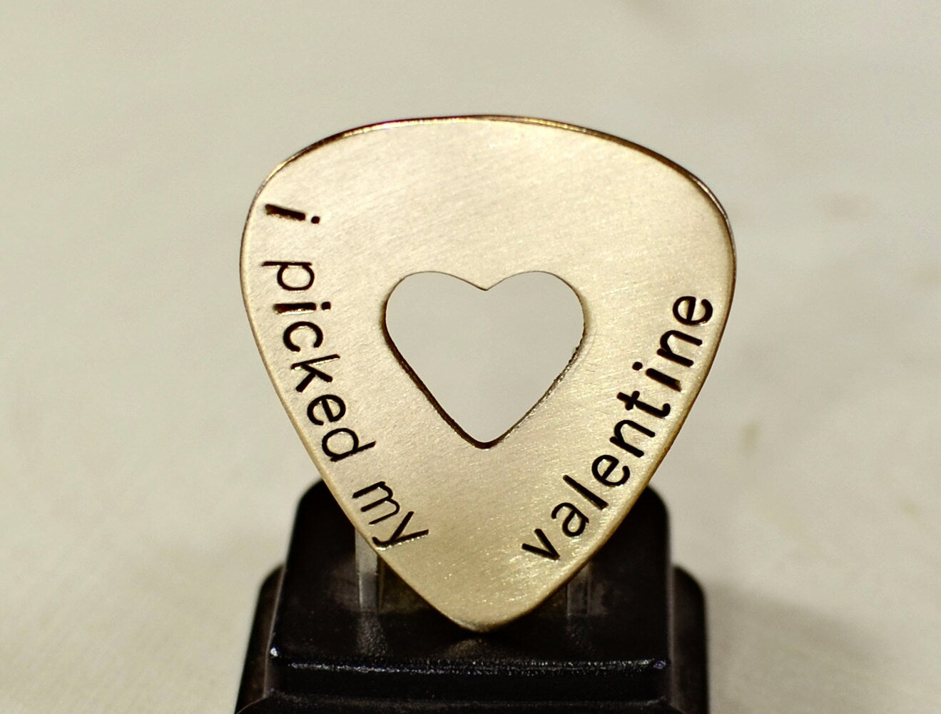 Valentines Day bronze guitar pick with a heart and message of love