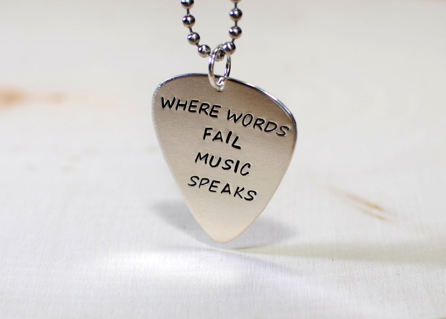 Necklace with Where words fail music speaks on sterling silver guitar pick