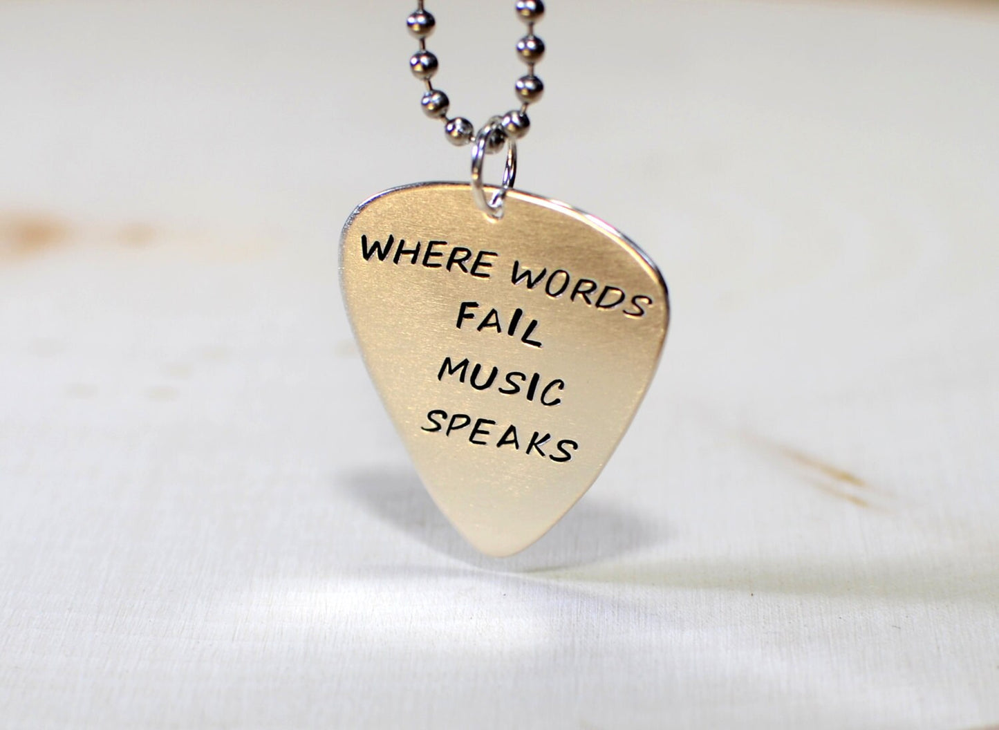 Necklace with Where words fail music speaks on sterling silver guitar pick