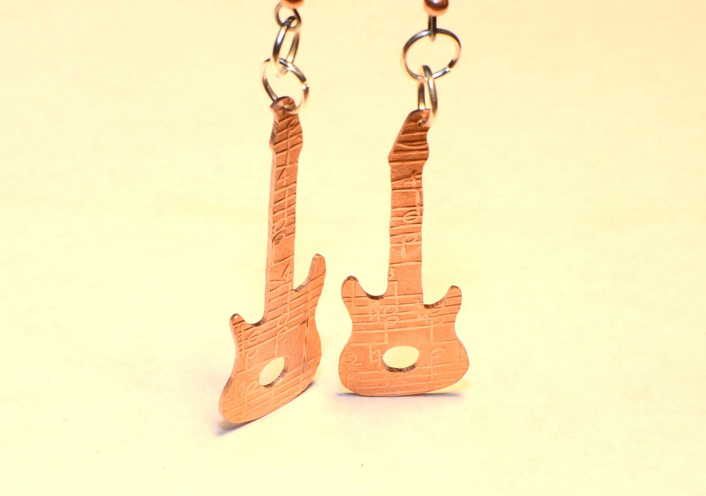 Copper guitar shaped earrings with music notes