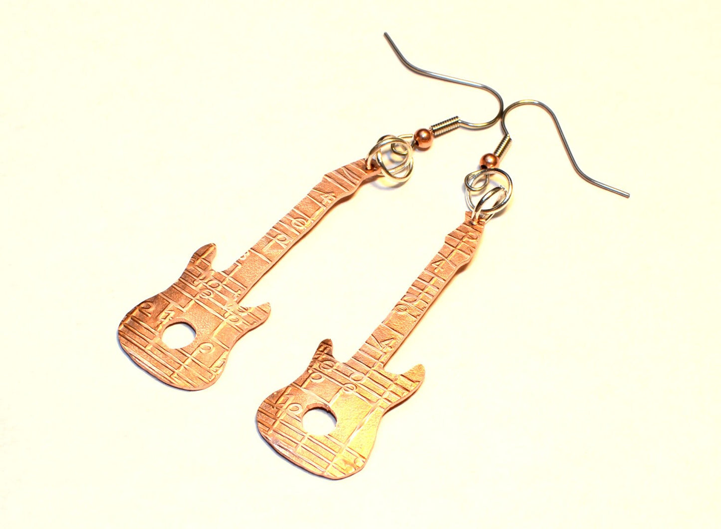 Copper guitar shaped earrings with music notes
