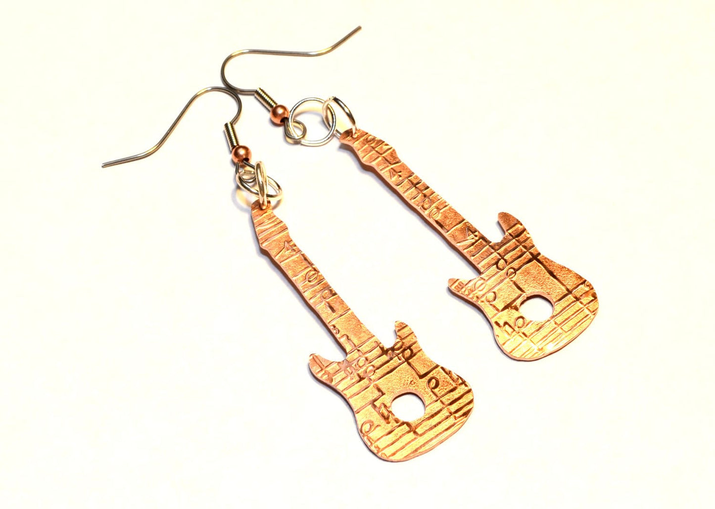 Copper guitar shaped earrings with music notes