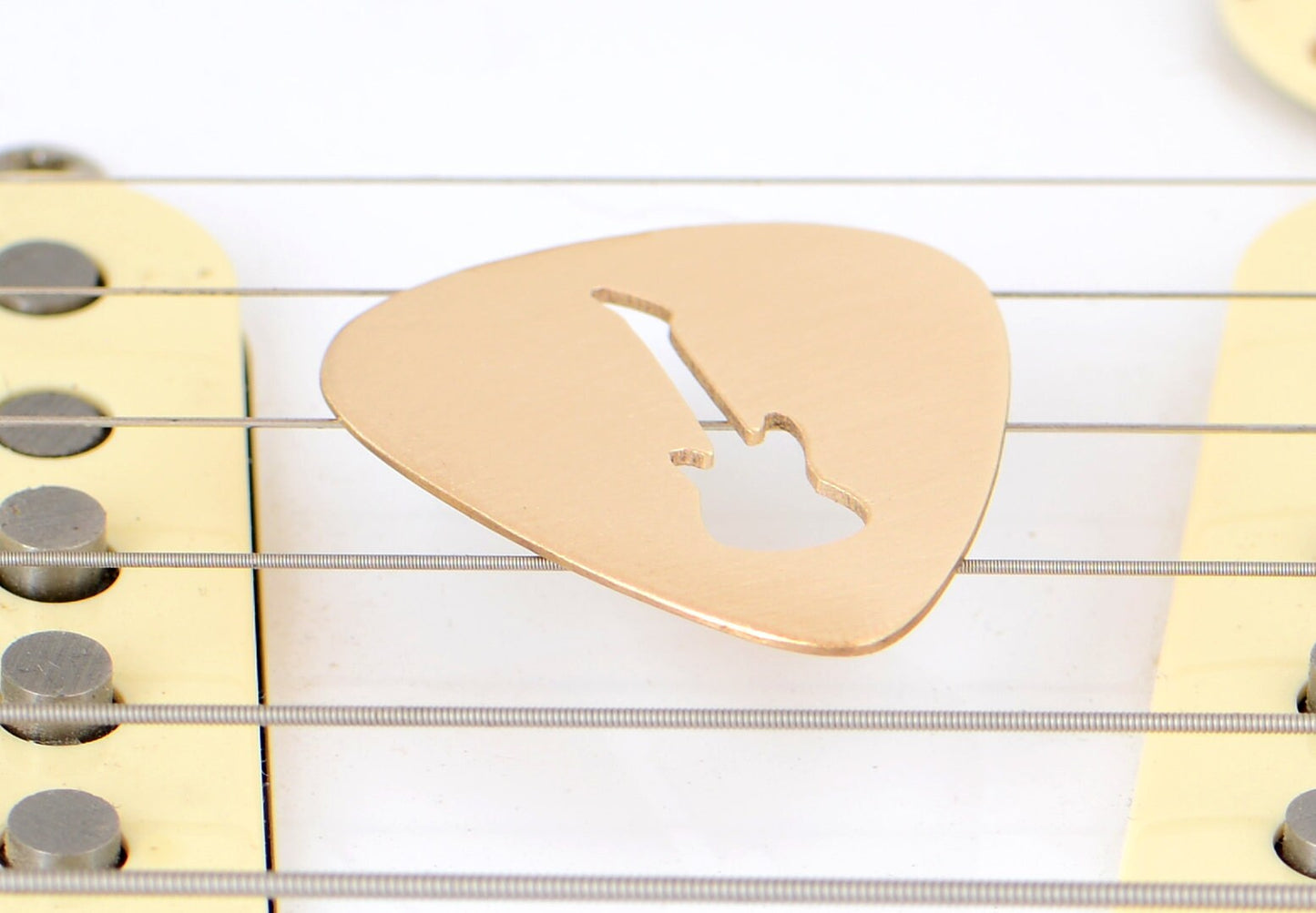 Bronze guitar pick with electric guitar cut out