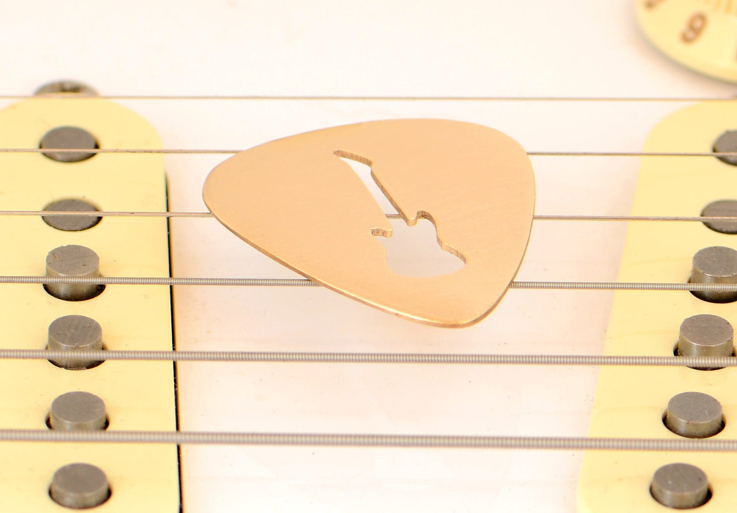 Bronze guitar pick with electric guitar cut out