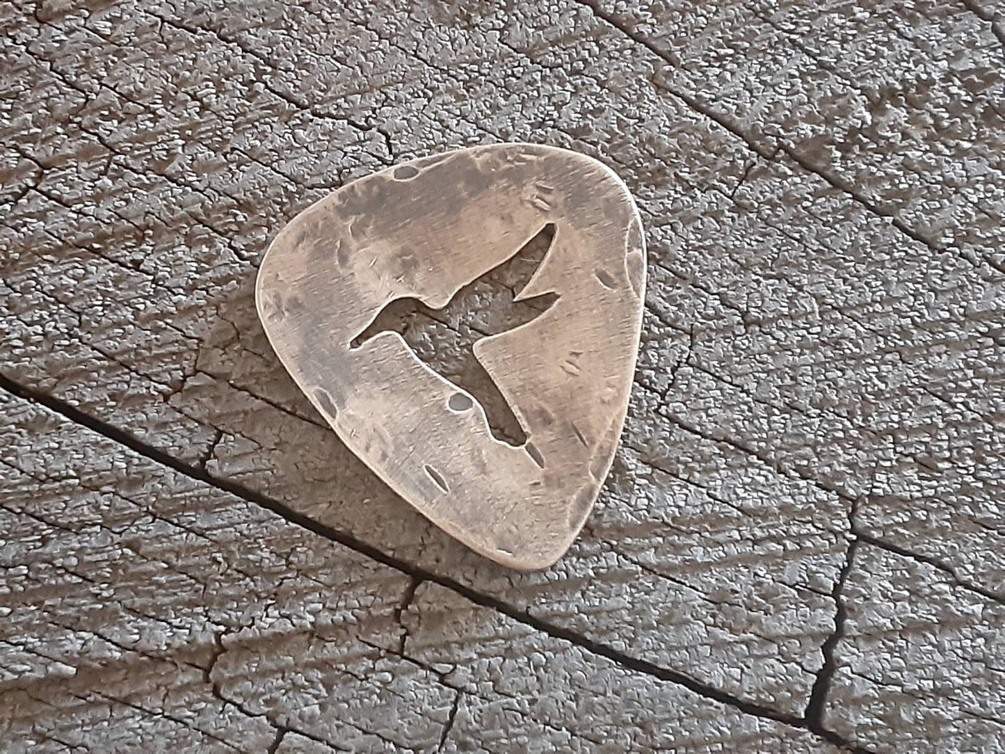 Bronze guitar pick with distressed finish