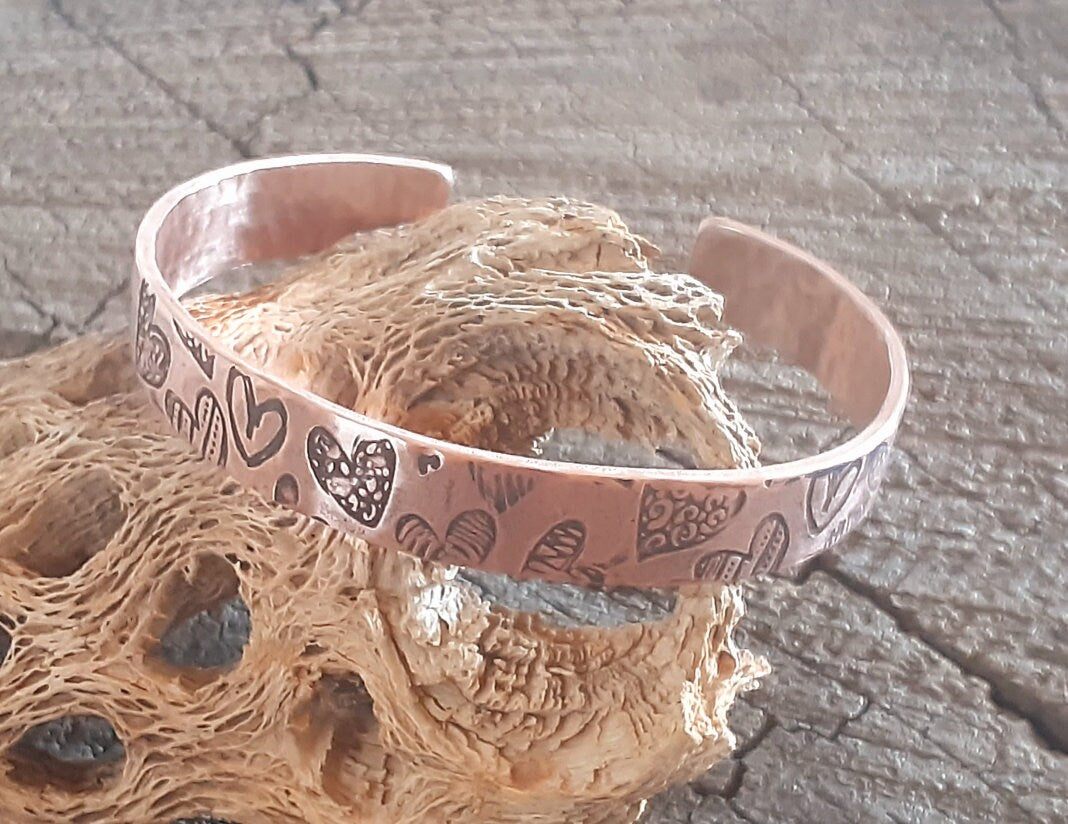 Copper cuff bracelet with hammed hearts