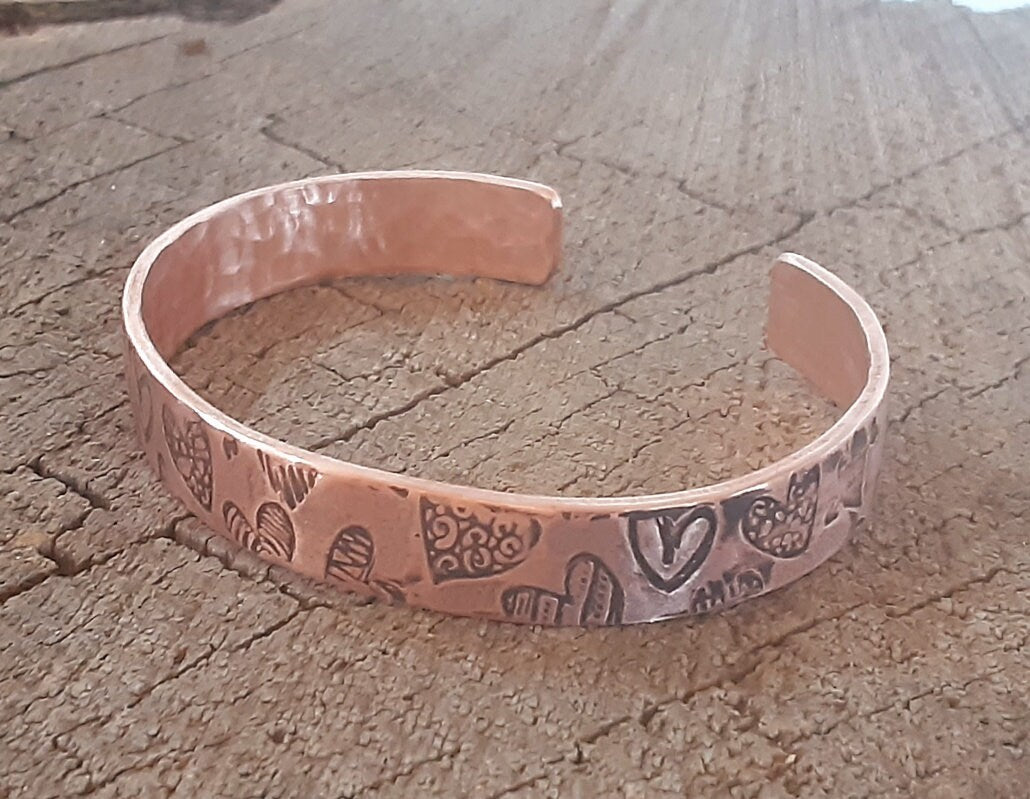 Copper cuff bracelet with hammed hearts