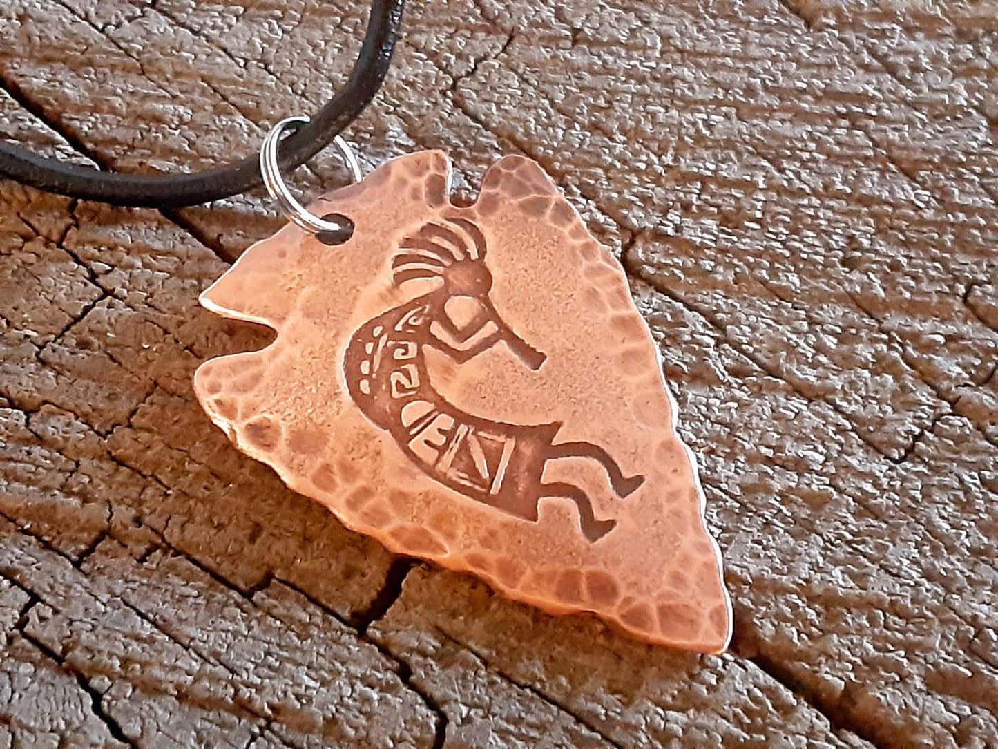 Copper arrowhead necklace with Kokopelli hung from an adjustable leather cord