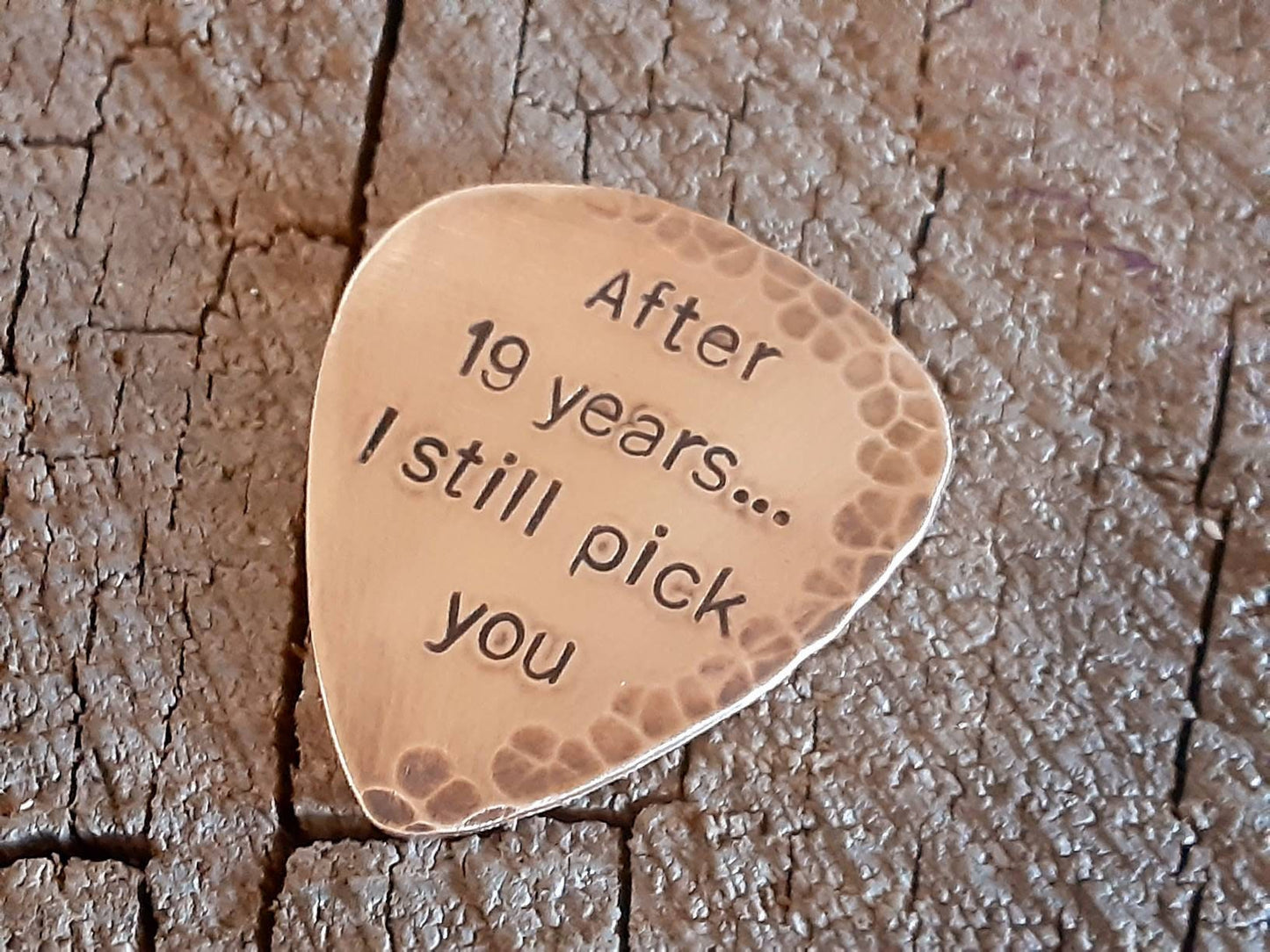 Bronze guitar pick with distressed rustic finishes