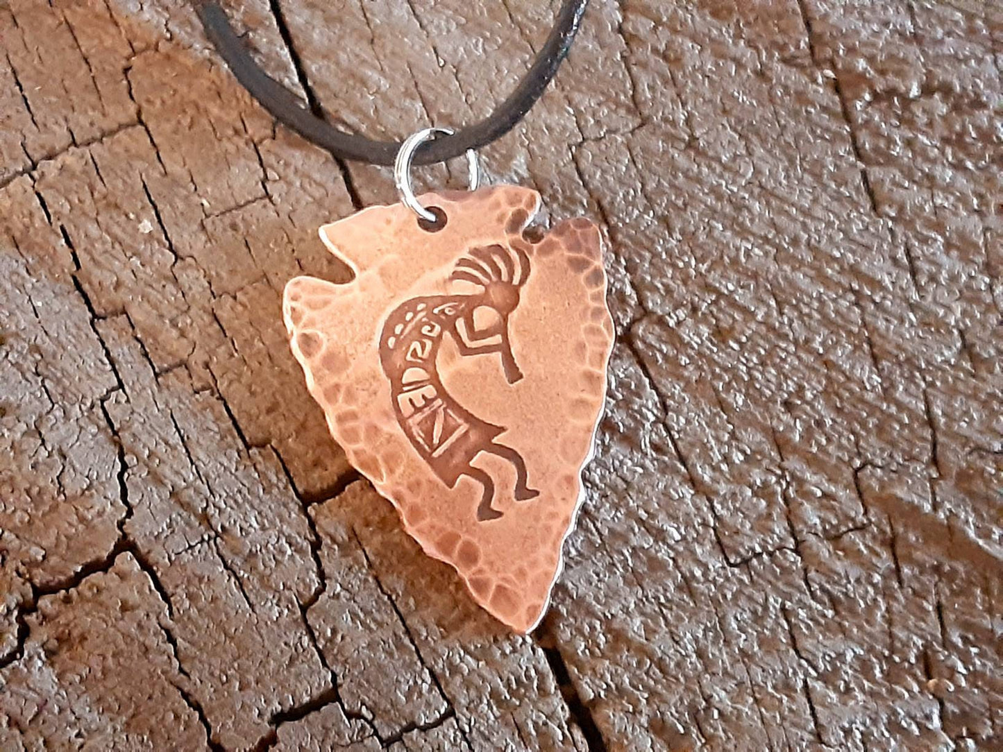 Copper arrowhead necklace with Kokopelli hung from an adjustable leather cord