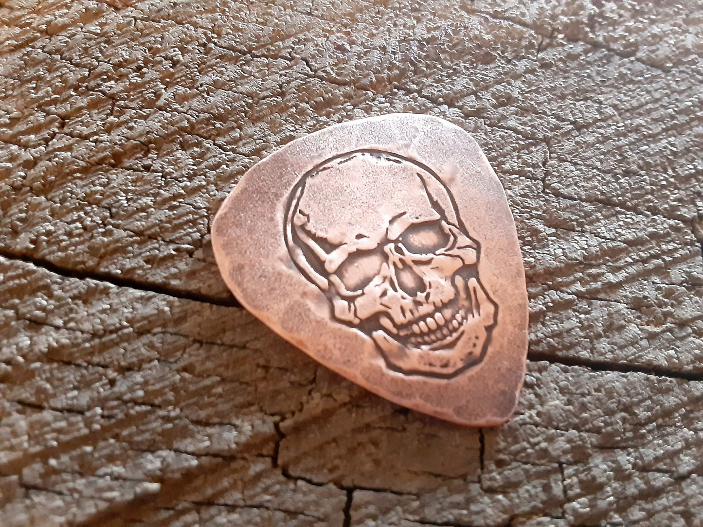 Playable copper guitar pick with skull design