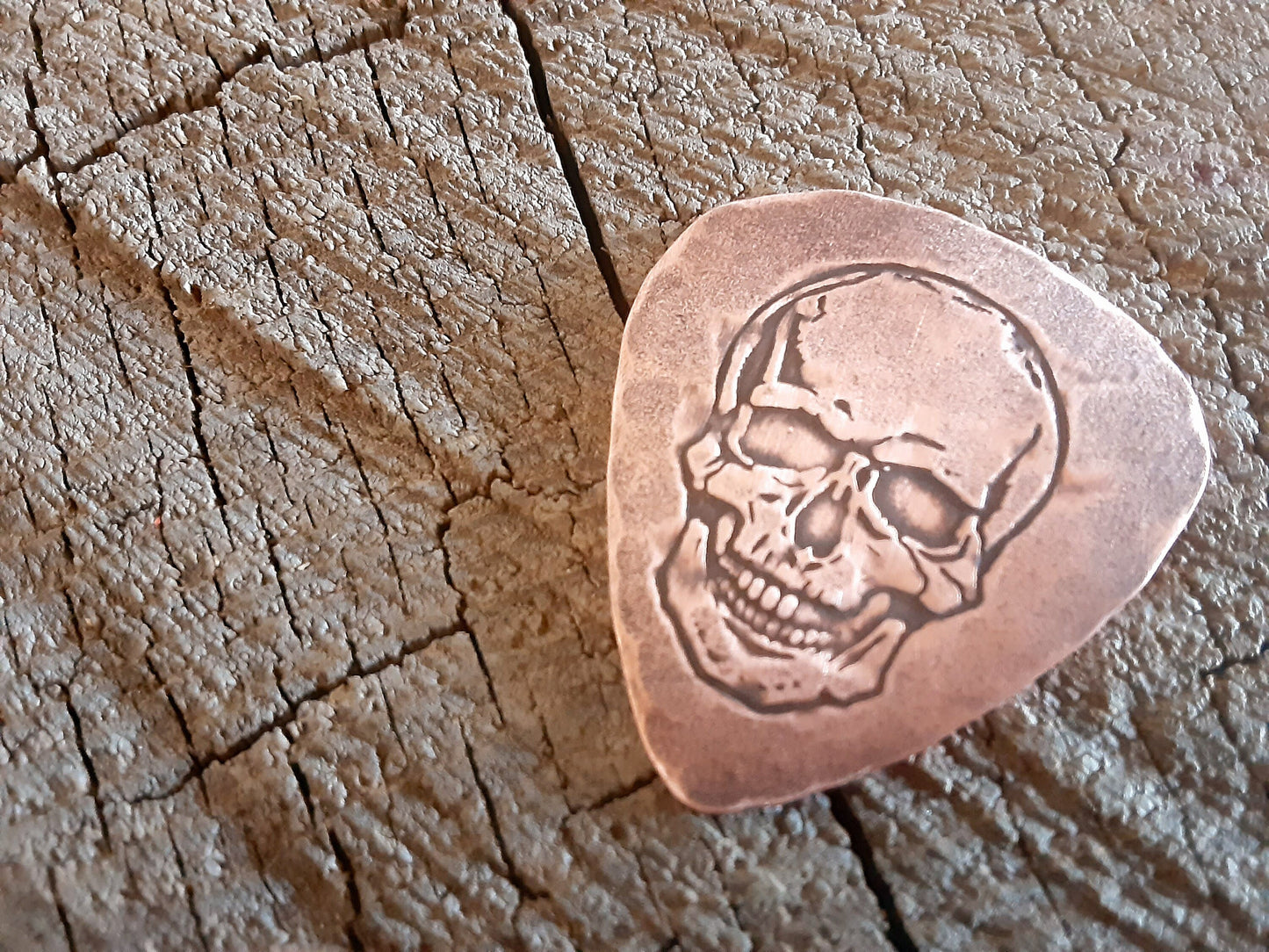 Playable copper guitar pick with skull design