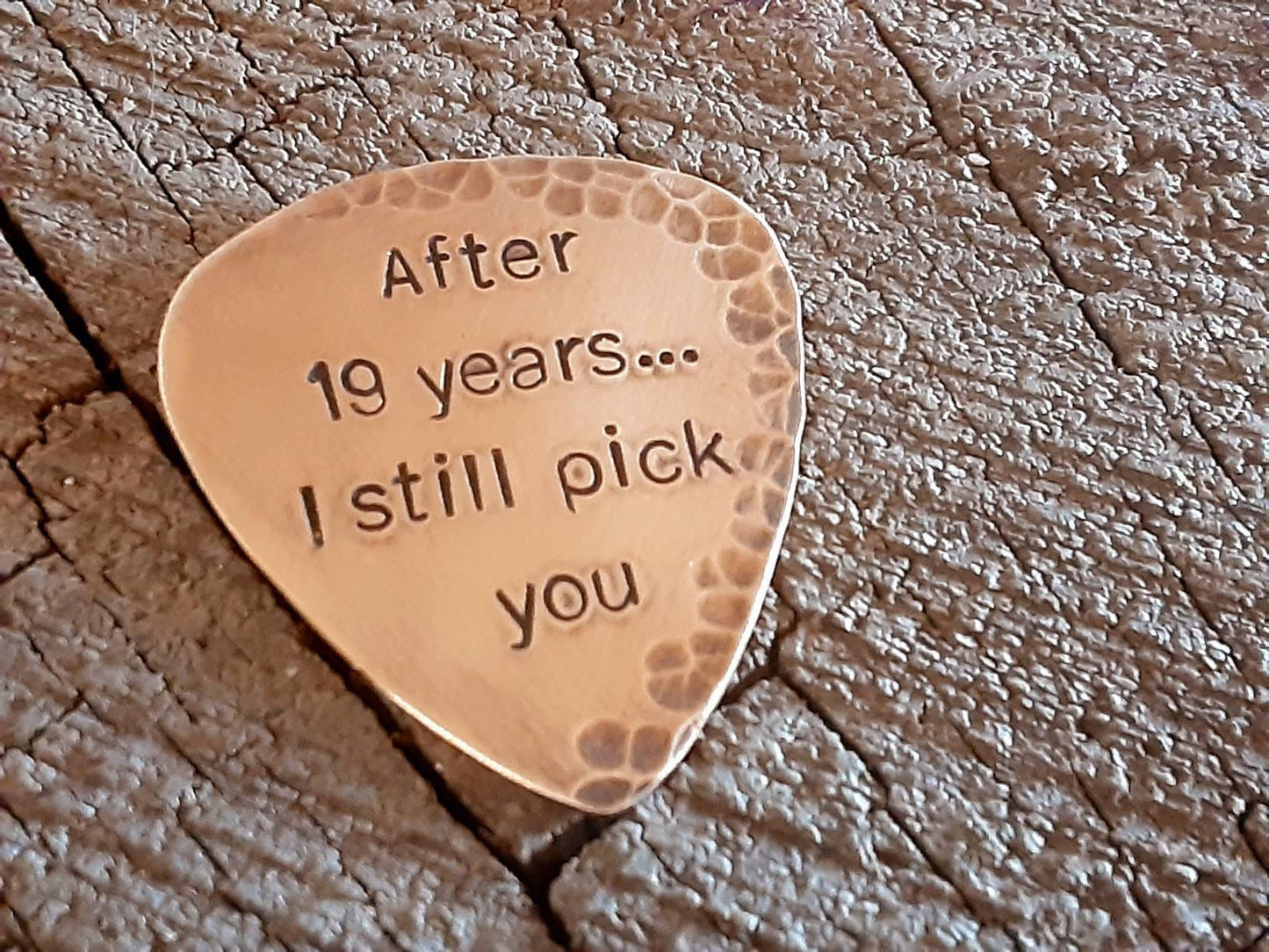 Bronze guitar pick with distressed rustic finishes