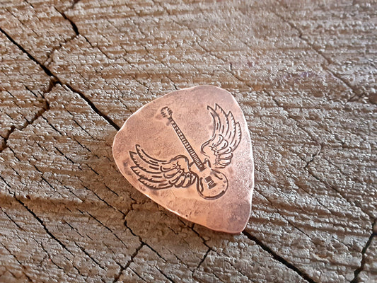 Winged guitar on copper guitar pick