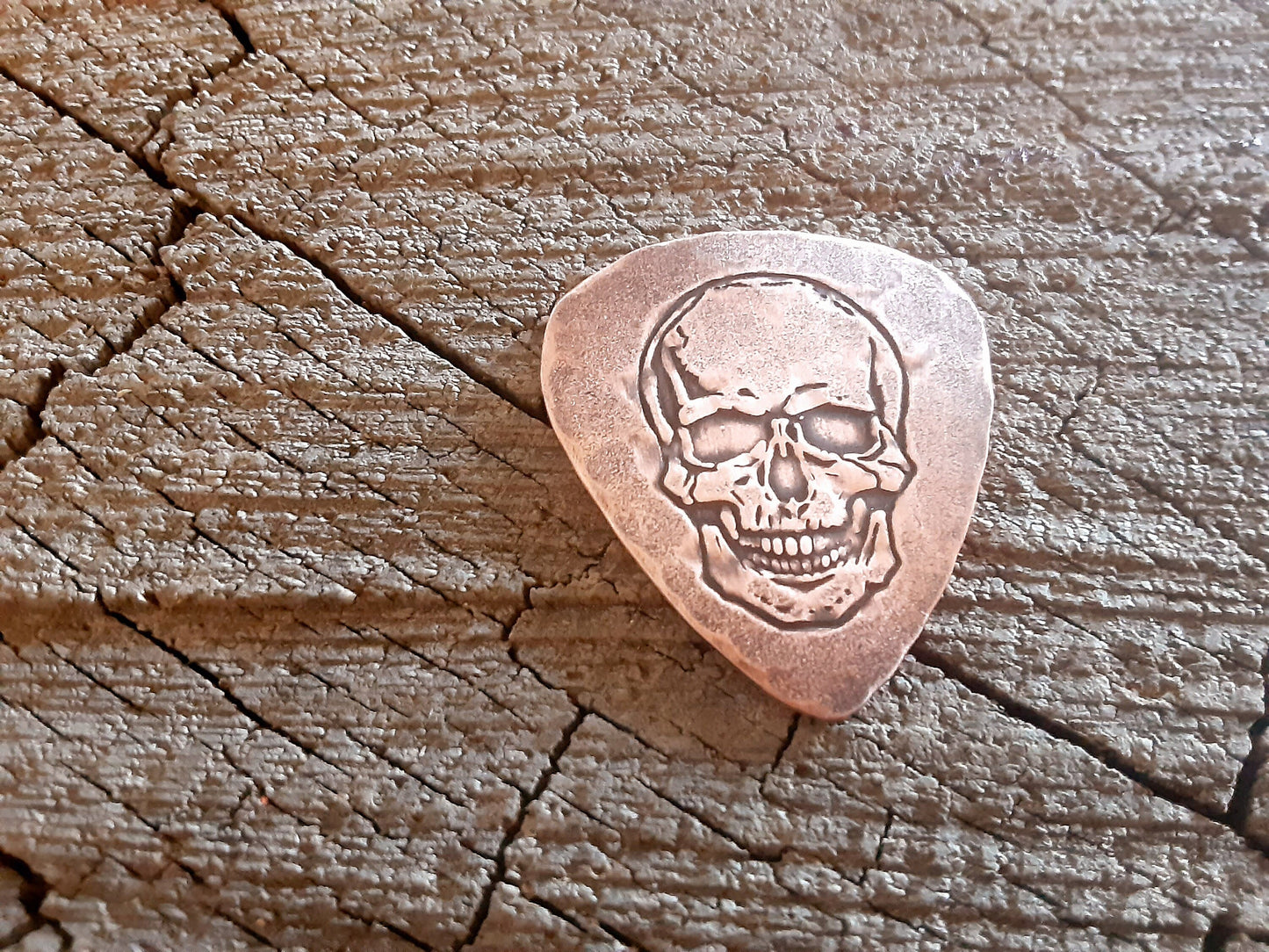 Playable copper guitar pick with skull design