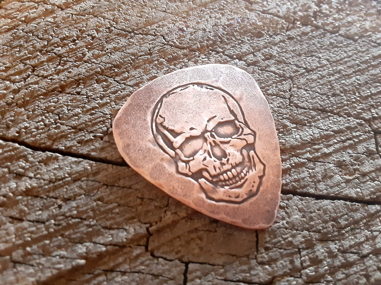 Playable copper guitar pick with skull design
