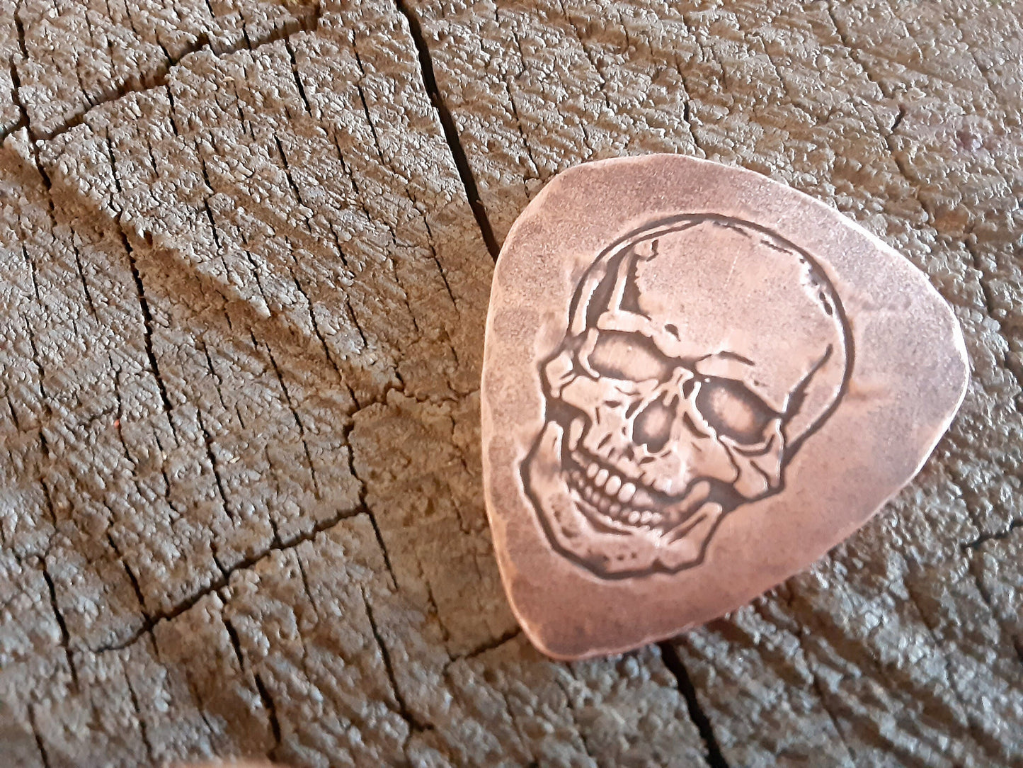 Playable copper guitar pick with skull design